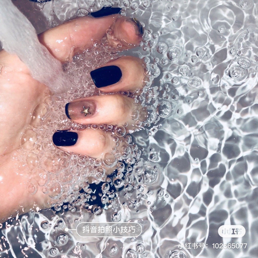 Black manicure under running water