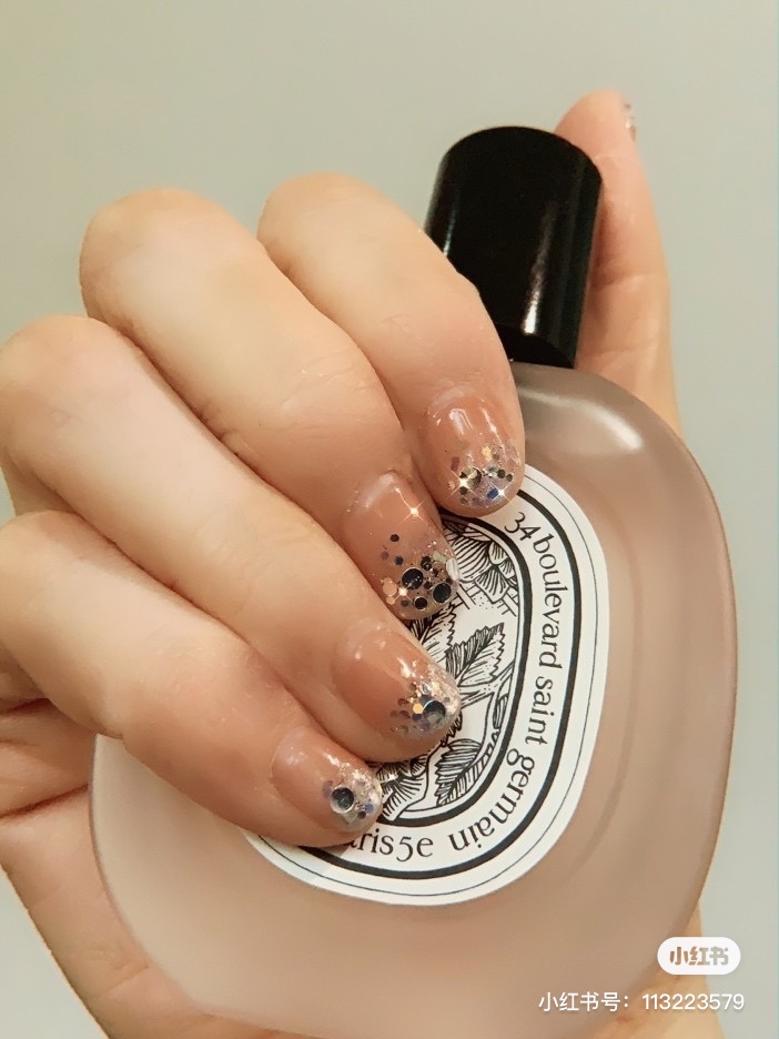 Glittery nails with diptyque perfume bottle