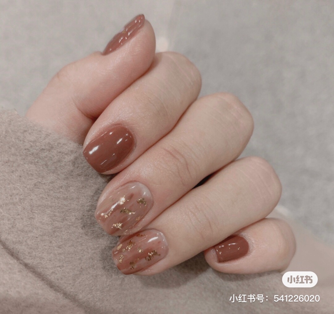 Dark brown nails with gold flakes