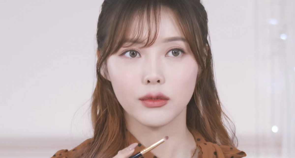 Pony applying eyeshadow on her upper lip