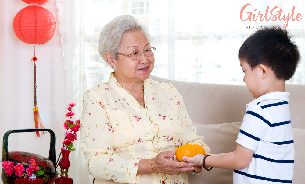 chinese new year grandchild giving mandarins to elders
