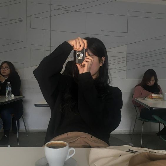 Girl taking photos in a cafe