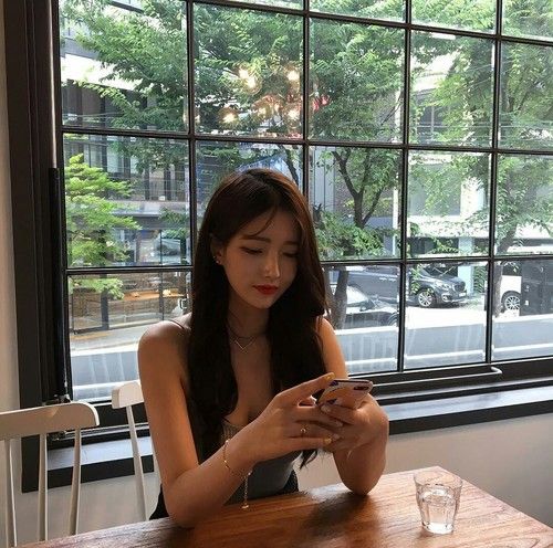 Girl using phone in a cafe