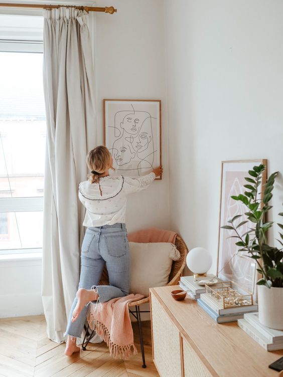 Girl hanging up an artwork