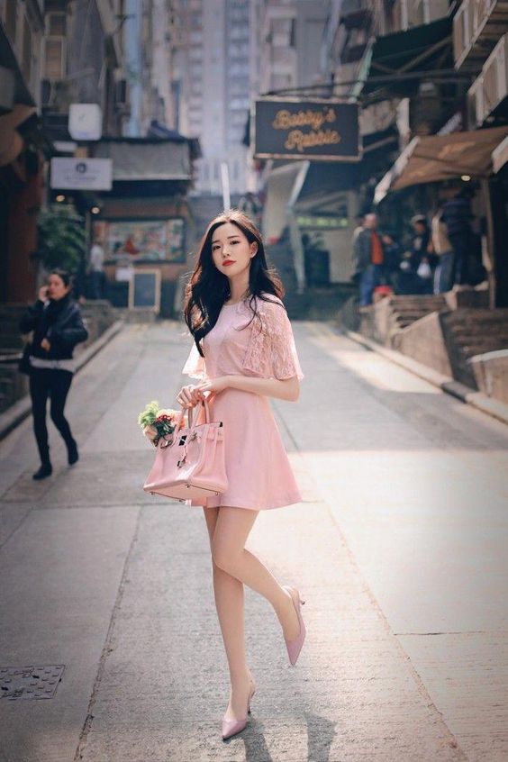 asian woman walking in heels in a pink dress