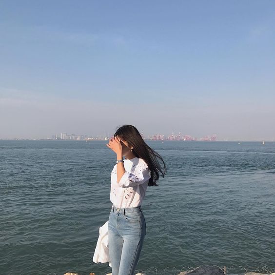 Girl at the beach covering her face