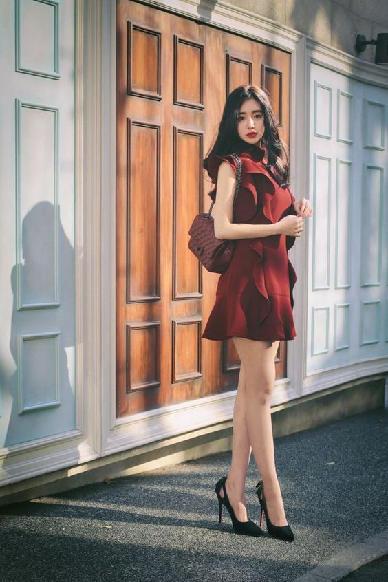 asian woman walking in heels in a red dress