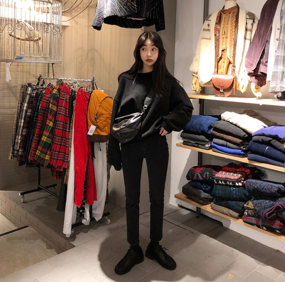 how to stop impulse shopping and save money, korean girl in clothing store wearing a sweater and jeans