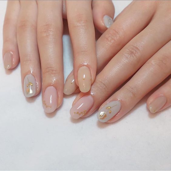 minimalist floral nails in nude with gold flowers