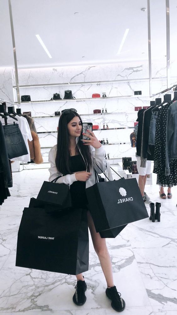 how to stop impulse shopping and save money, woman taking a selfie in a store with multiple shopping bags