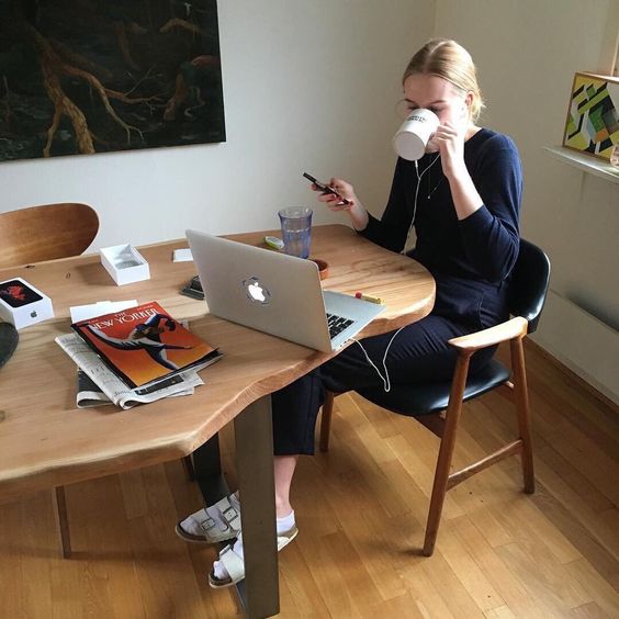 Girl drinking from a cup and using her phone