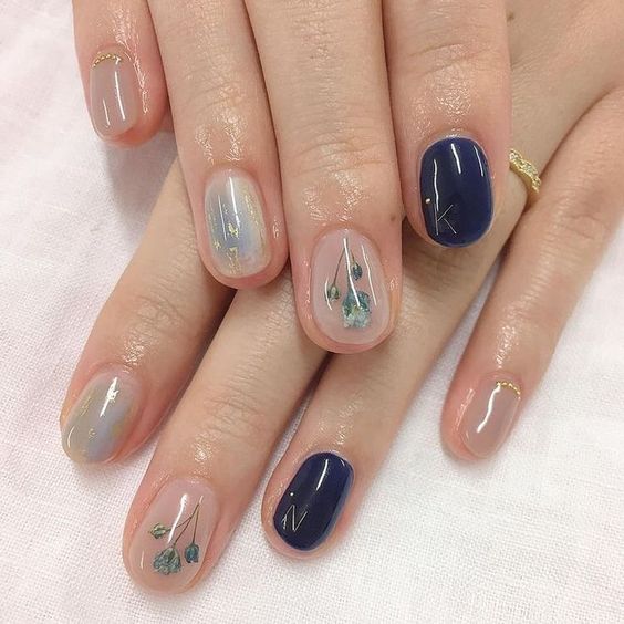minimalist floral nails in dark blue with light blue flowers