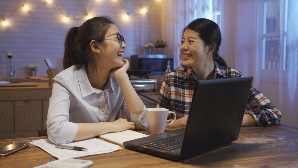 Two girls laughing while doing work