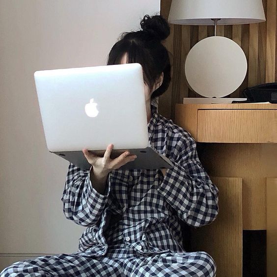 Girl in pyjamas typing a laptop