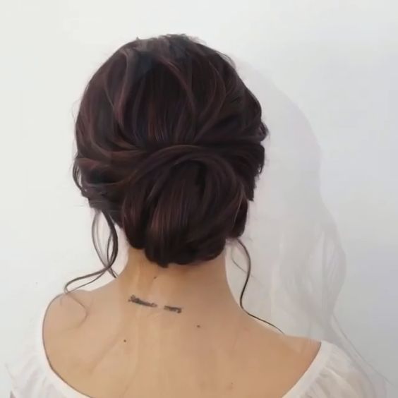asian woman with hair in a bun and a tattoo on the back of her neck