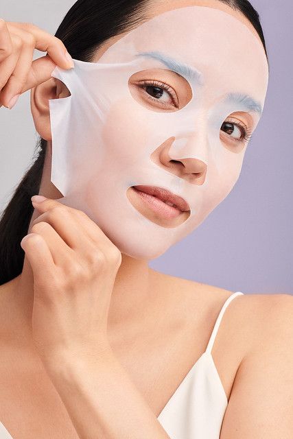 Girl using a sheet mask on her skin