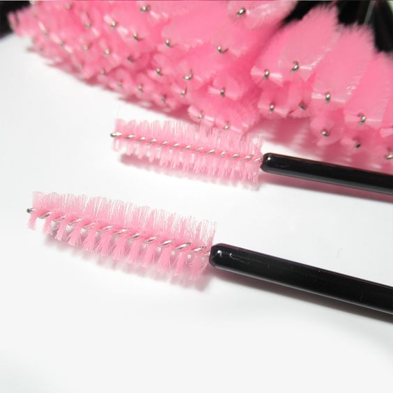 a bunch of pink and black lash brushes