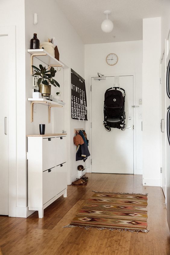 small entryway with storage for shoes, hats, gloves and a calendar