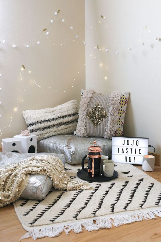cosy reading nook with grey colour scheme, pillows, blankets and drinks