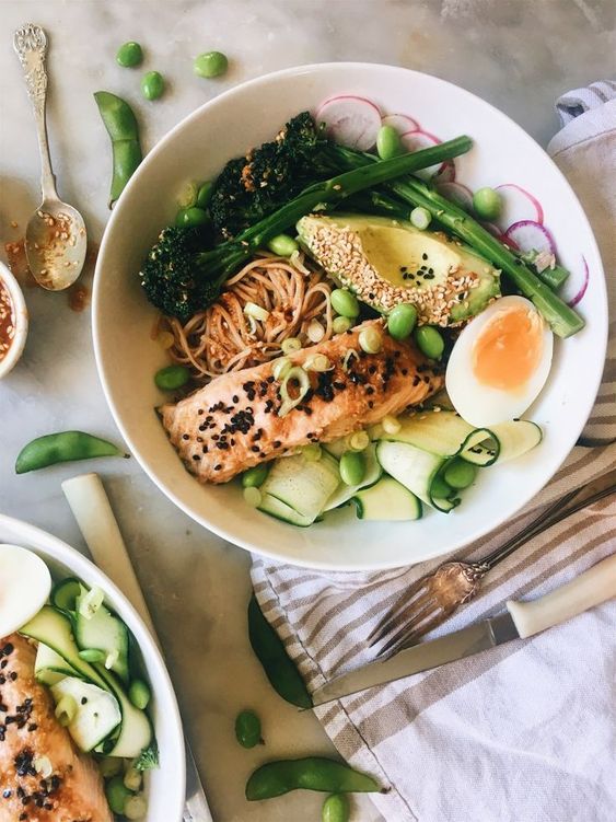 a bowl of salad with salmon and eggs