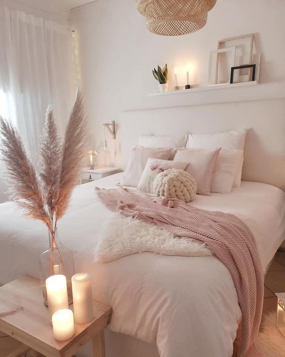 pink and white bedroom with candles and feathers