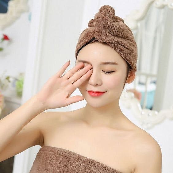 asian woman with a brown towel wrapped around her head and body
