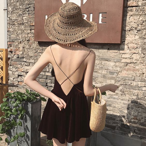 asian girl wearing a black backless dress and a big hat