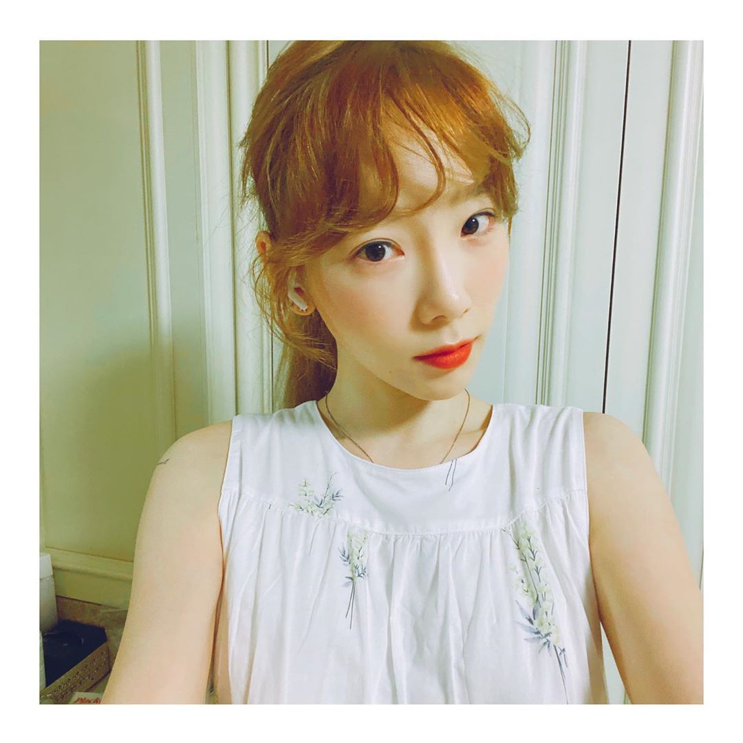 Taeyeon with caramel brown tied up hair and curled