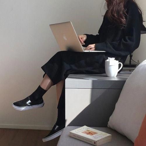 asian girl using MacBook laptop at home with a drink and book