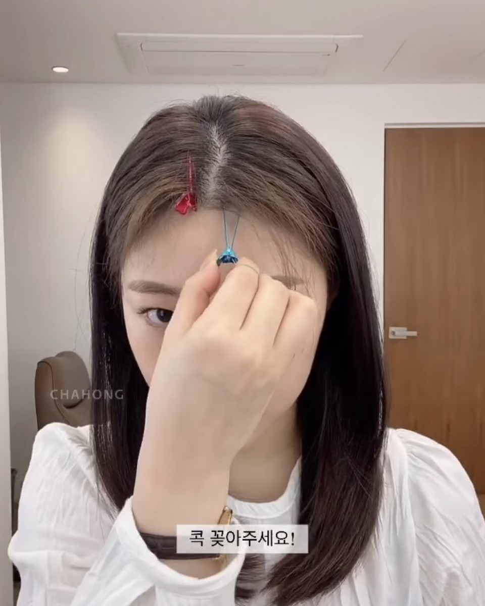 asian girl styling middle hair parting with clips