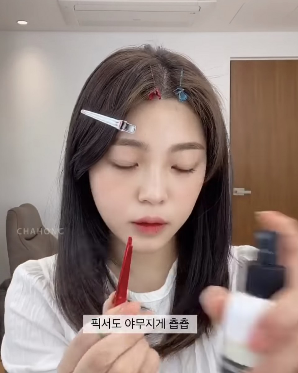 asian girl styling middle hair parting with hairspray clips