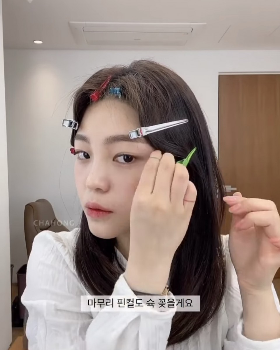 asian girl styling middle hair parting with multiple clips