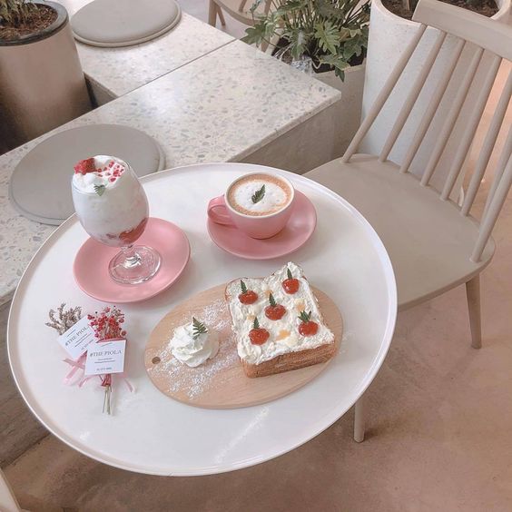 white round cafe table with pink dinnerware and strawberry toast and drinks