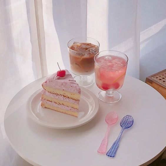 korean cafe table with coffee, a pink drink, cake and pink and purple cutlery
