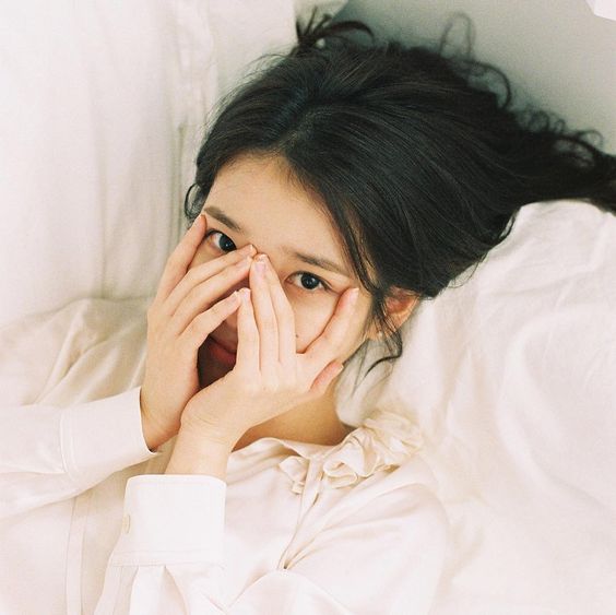 asian girl covering her face while revealing only her eyes
