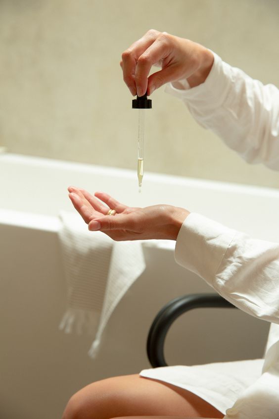 Applying serum onto palms using a dropper