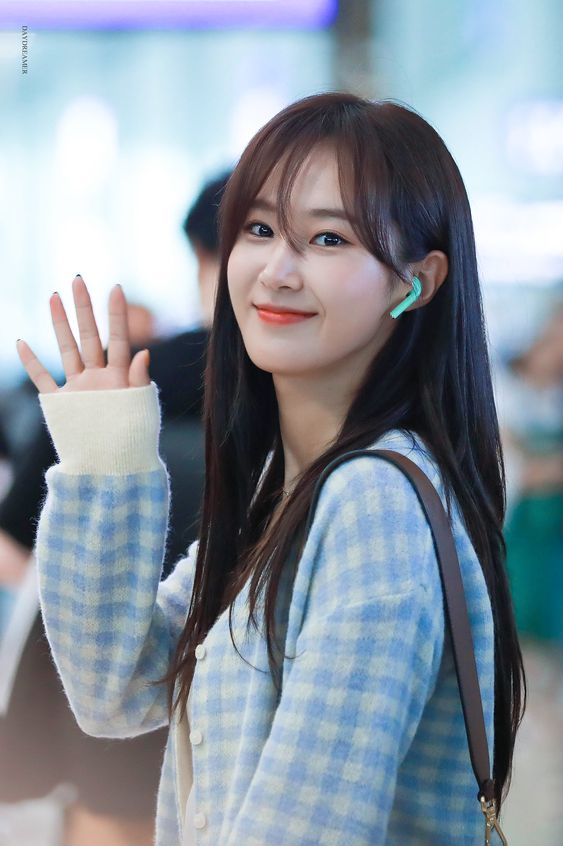 Yuri from SNSD or girls generation with long hair and airy bangs wearing a blue checkered top and blue wireless EarPods or AirPods