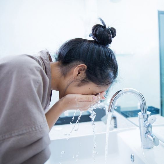 Girl washing her face