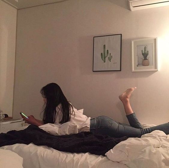 asian girl using her phone while lying in bed