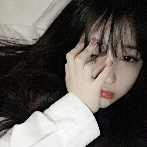 asian girl with bangs looking sad with hand covering her face
