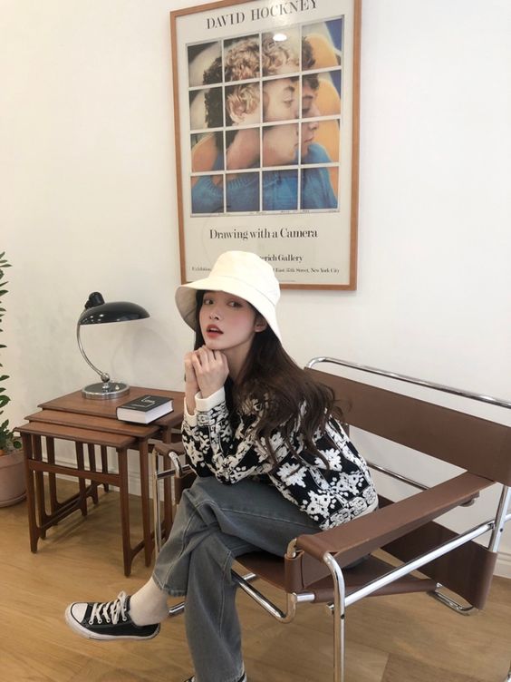 asian woman wearing a white hat and sitting with legs crossed