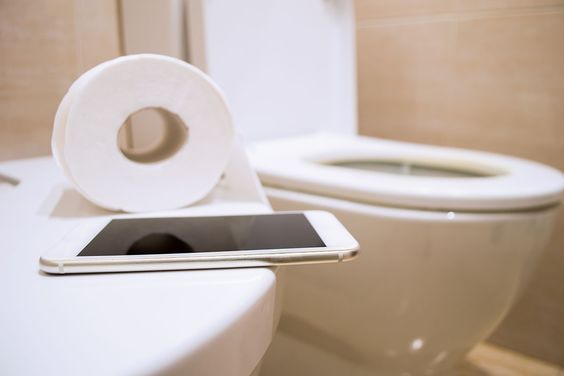 phone and toilet paper in a bathroom