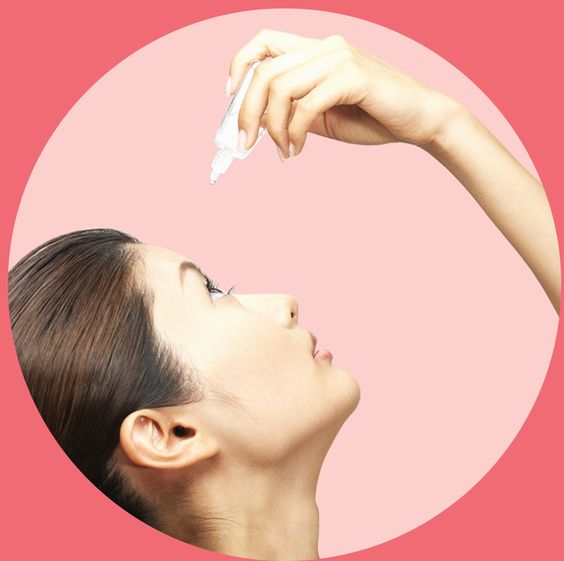 asian woman applying eye drops