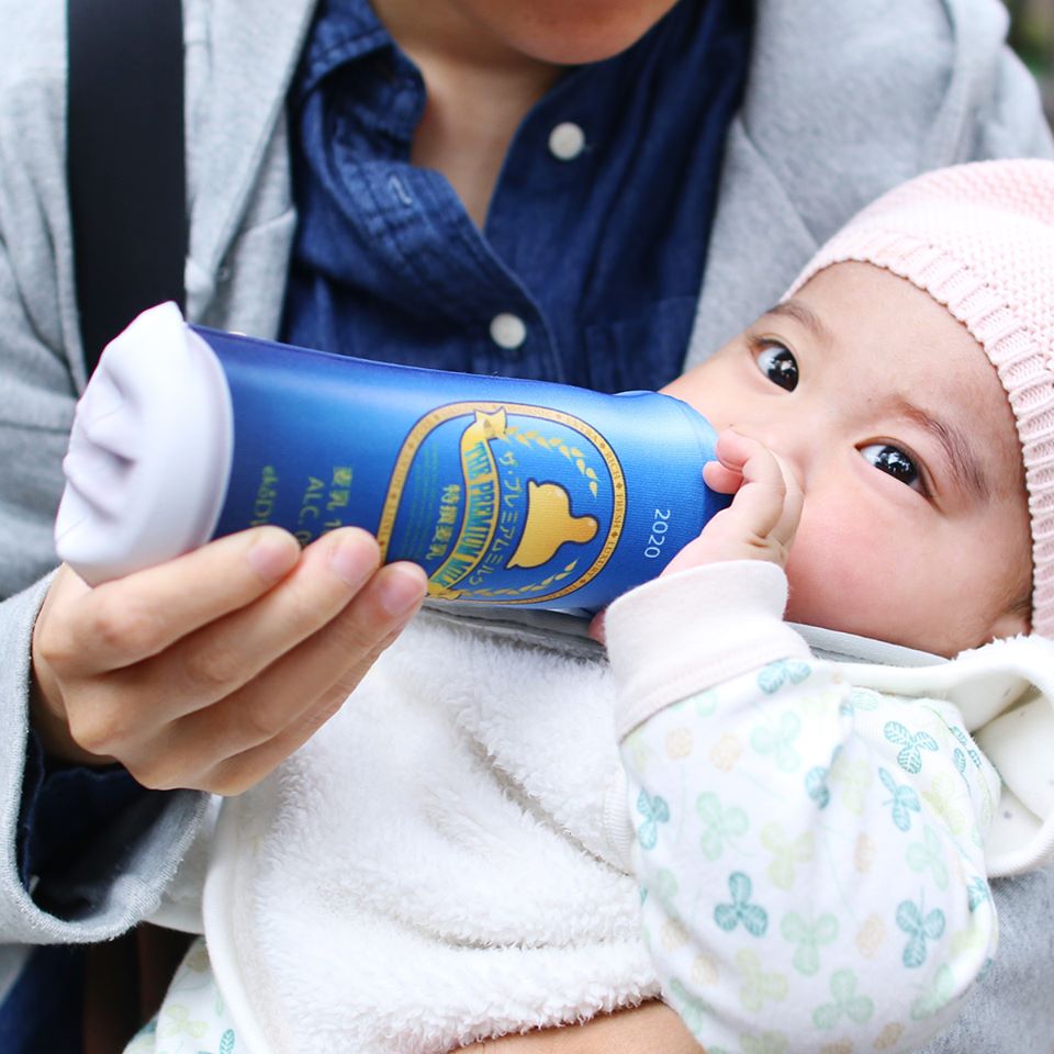 baby drinking out of milk bottle that looks like beer premium milk