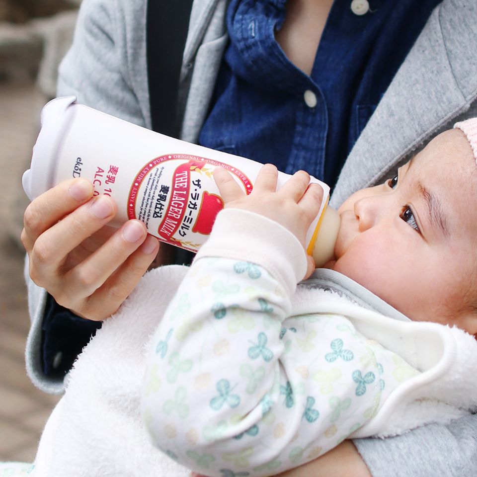 baby drinking out of milk bottle that looks like beer lager milk 