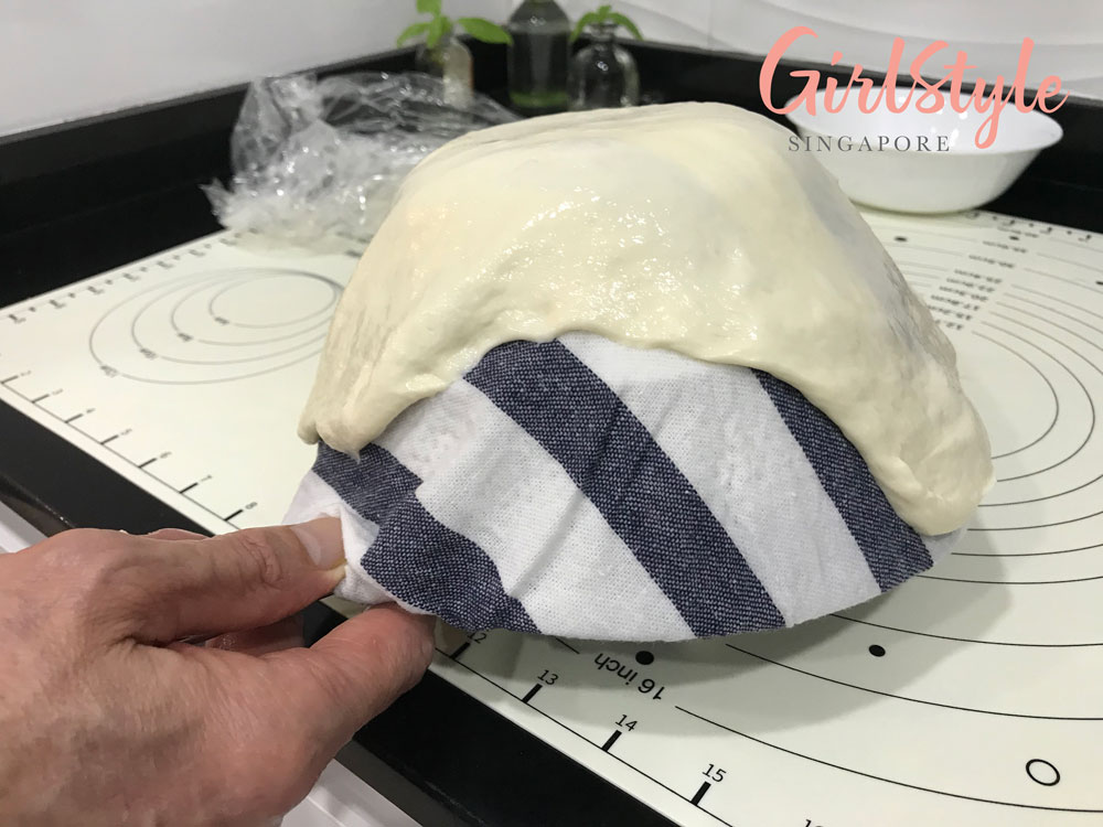 shape butter and garlic naan on damp cloth