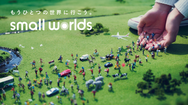 miniature people walking towards hand in Small Worlds Tokyo