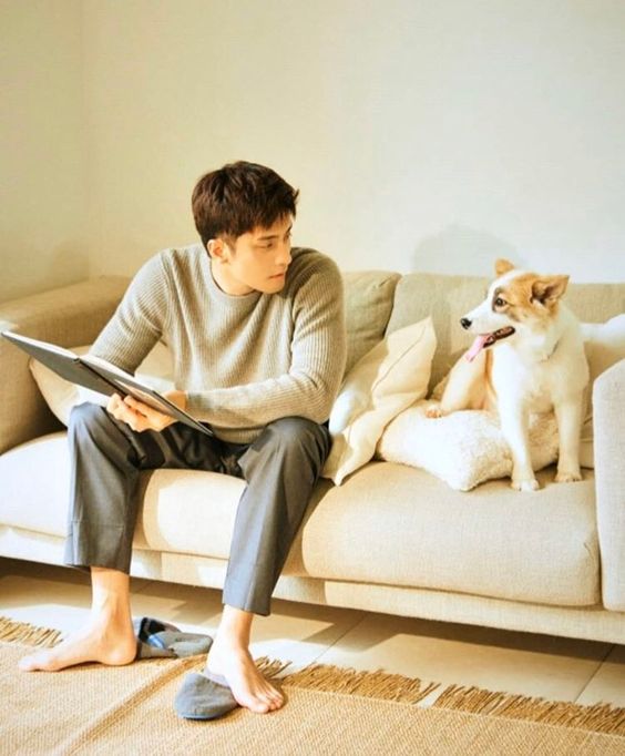 asian buy sitting on sofa couch with his jack russell dog