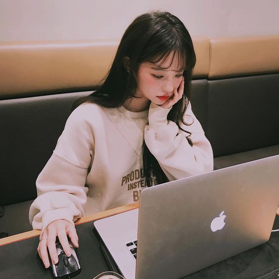 asian girl with bangs and long hair on her MacBook laptop