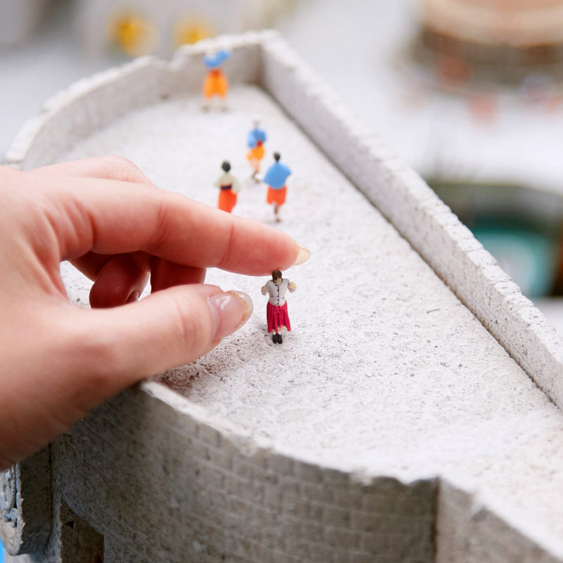 hand touching miniature figure in Small Worlds Tokyo